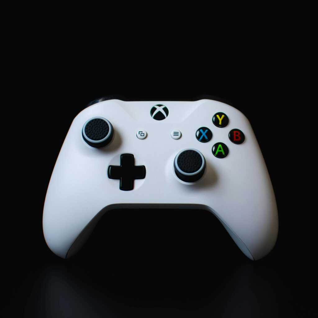 Close-up of a white Xbox controller against a dark backdrop, highlighting its design.