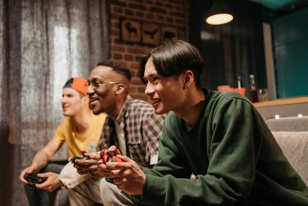 Diverse group of young adults enjoying video games together indoors, creating a fun and social atmosphere.